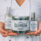 Woman holding the Palo Santo & Saffron candle, cologne and room spray