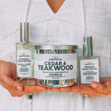 Woman holding the Cedar & Teakwood candle and room spray