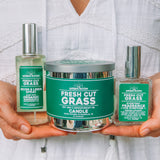 Woman holding the Fresh Cut Grass candle, room spray and cologne