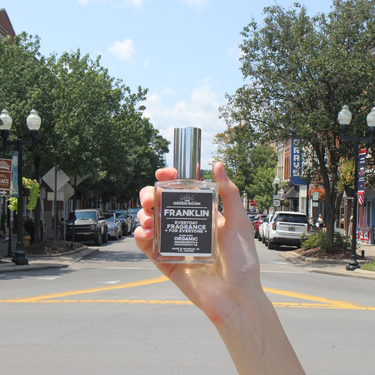 Hand holding the Franklin cologne on Main Street in downtown Franklin, Tennessee