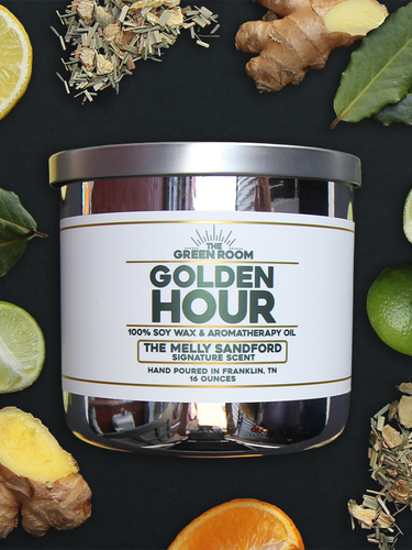 Golden Hour 100% soy wax candle with lemon, fresh ginger, citrus halves and dried botanicals on a black background
