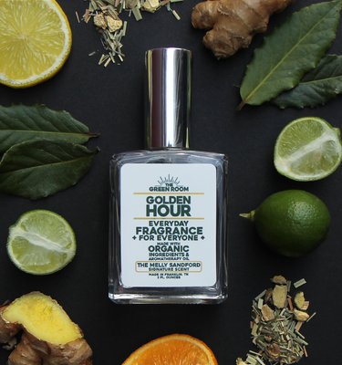 Golden Hour cologne with lemon, fresh ginger, citrus halves and tea leaves on a black background