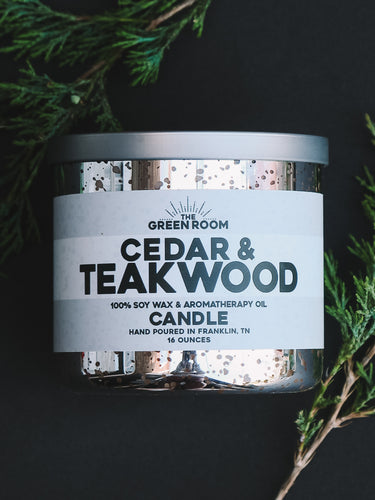 Cedar & Teakwood 100% soy wax candle with fresh cedar sprigs on a black background