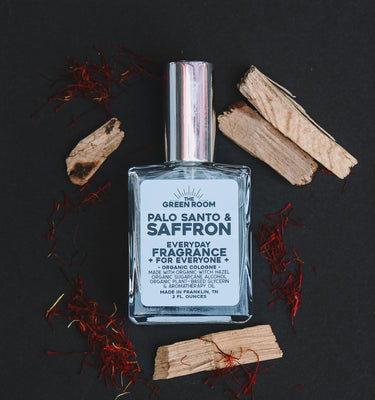 Palo Santo & Saffron cologne with palo santo sticks and saffron threads on a black background