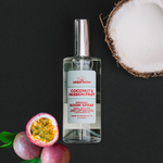 Coconut & Passionfruit room spray with a split coconut and fresh passion fruit on a black background