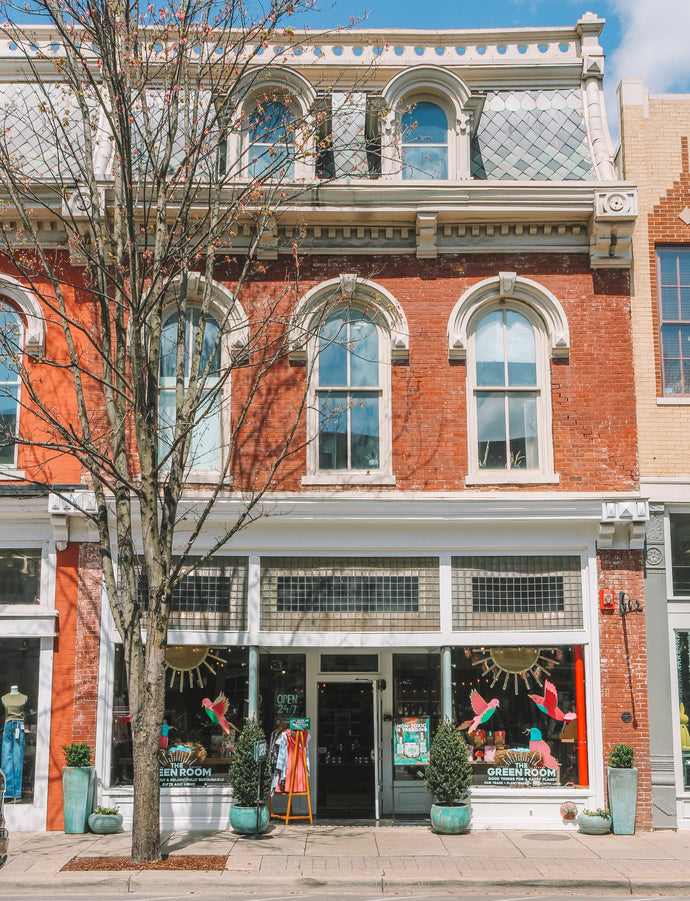 The Green Room storefront in a historic red brick building with white trim, arched windows, and a sidewalk on Main Street in Franklin, TN.